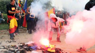Colectivos de ultraderecha portan banderas preconstitucionales mientras queman banderas esteladas y propaganda independentista. FOTO: EFE
