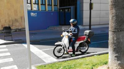 Un hombre se desplaza por el centro de Tarragona sobre un ciclomotor, en una imagen que cada vez será más difícil de captar. FOTO: A. S.