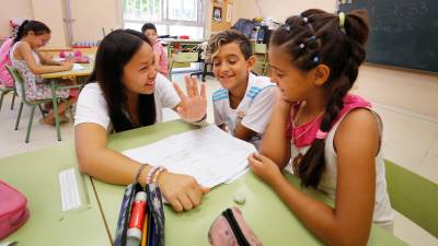 A primera hora los niños y niñas hacen sus deberes con la ayuda de las monitoras y los voluntarios que ofrecen sus conocimientos. FOTO: PERE FERRÉ