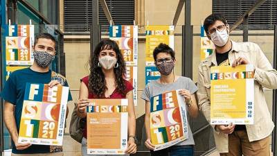 Algunos de los organizadores de Fira ira d’Economia Solidària con el cartel de las jornadas. FOTO: CEDIDA