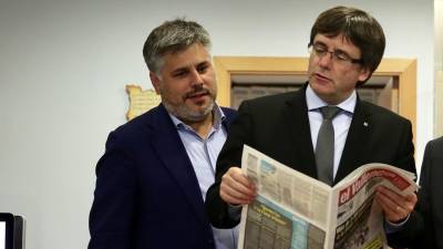 El president Puigdemont ojea un ejemplar de ‘El Vallenc’ junto al alcalde de Valls, Albert Batet. FOTO: RUBÉN MORENO