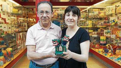 El padre Lluís Fabregat junto a su hija Gemma Fabregat y el Drac, el nuevo juguete de Sant Joan, en su tienda. FOTOs: alba tud