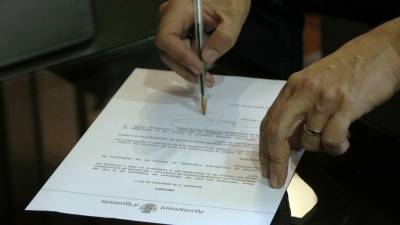 Detalle del decreto de apoyo al referèndum de l'1-O en el momento en que firma el alcalde de Igualada. Foto: ACN