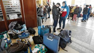 Ciudadanos ucranianos, recién llegados con su equipaje, esperan en el vestíbulo para quedar alojados en Ohtels La Hacienda, en La Pineda. Foto: Pere Ferré