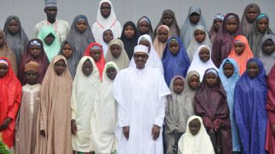 El presidente nigeriano, Muhammadu Buhari (frente) posa con las niñas del colegio Dapchi, liberadas tras el secuestro del grupo yihadista Boko Haram