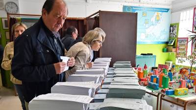 Un elector mirando las diferentes papeletas en un colegio electoral de Reus. FOTO: Alfredo González