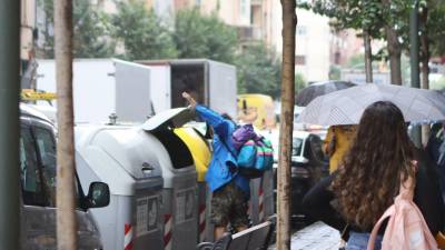 Una persona rebuscando comida en el interior de un contenedor de la calle Pere Martell, durante la semana pasada. FOTO: ALBA MARINÉ