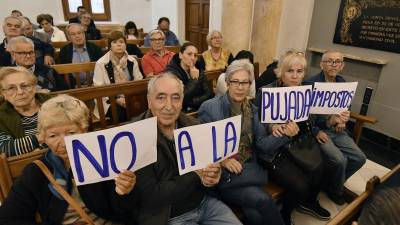 Vecinos de Reus exhibiendo pancartas en el pleno en contra de la subida de impuestos. Foto: Alfredo González