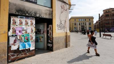 Un local cubierto de carteles y pintadas en plena plaza Corsini. FOTO: PERE FERRÉ
