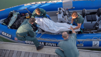 Varios efectivos que trasladan el cuerpo sin vida de un inmigrante fallecido en el naufragio de Cádiz. FOTO: EFE