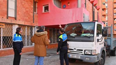Dos agentes de la Guàrdia Urbana y el presidente de la comunidad ante el piso que se tapió en el barrio Gaudí. FOTO: ALFREDO GONZÁLEZ