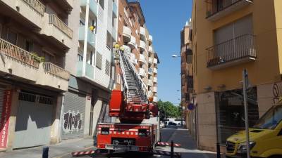 Momento en el que los bomberos han accedido a la vivienda de la mujer. Foto: Alba Mariné
