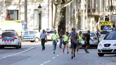 Efectivos policiales se despliegan en el centro de Barcelona, mientras algunos ciudadanos huyen del lugar de la tragedia, poco después del ataque. Foto: efe