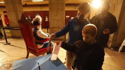 Imagen de dos niños introduciendo sus cartas en el buzón después de haber saludad al paje real en el Pati Jaume I. FOTO: PERE FERRÉ