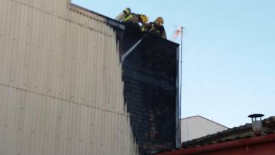 Los Bombers de la Generalitat, en el tejado del edificio afectado por el incendio de Torredembarra.