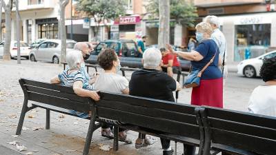 Varias personas mayores charlando en un banco del paseo Prim de Reus. Foto: A.M.