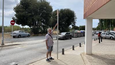 El presidente de la entidad vecinal, Eduardo Navas, muestra restos de un espejo de tráfico arrancado de su poste. FOTO: Alba Mariné