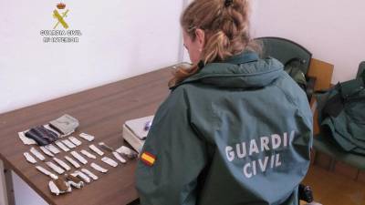 Una agente de la Benemérita con las diferentes dosis encontradas en la tienda. FOTO: Guardia Civil