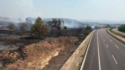 La proximitat de les flames a l'autopista i la presència de fum ha obligat a tallar el trànsit. Foto: A. Juanpere.
