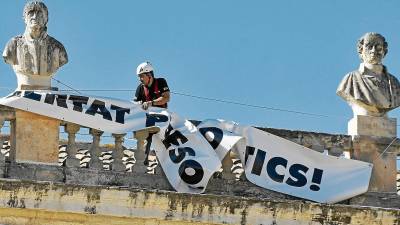 Imagen de ayer del momento en el que los operarios retiraron la pancarta, que estaba colgada desde el pasado 25 de julio. FOTO: Alfredo González