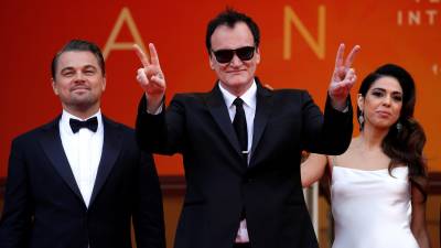 El actor Leonardo DiCaprio (i), el cineasta Quentin Tarantino (c) y su esposa, la cantante Daniella Pick.