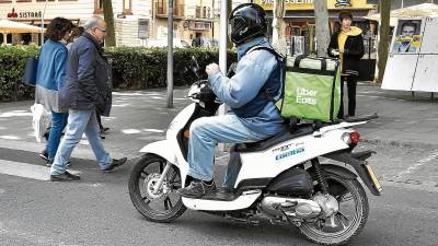 Un repartidor de Uber Eats en el centro de Reus. La motocicleta, la bici o incluso el patinete son los medios de locomoción empleados. Foto: Alfredo González