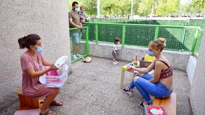 Reunión al aire libre entre madre y educadora en El Ninot. Foto: Alfredo González