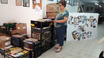 Una voluntaria clasifica los libros recuperados.