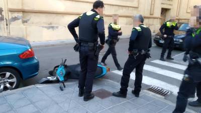 Los agentes con el ciclomotor, que fue abandonado por el ladrón. FOTO: Jordi Sanvisens