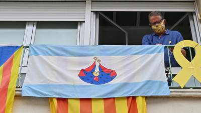 Un reusenc penja la bandera de Misericòrdia al seu balcó. FOTO: A.G.