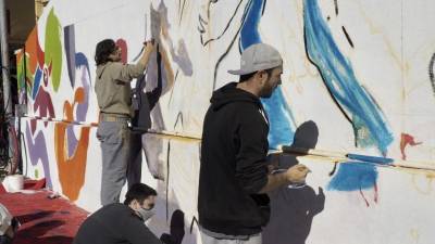 Alumnes d‘art treballant en el mural. FOTO: JOAN REVILLAS