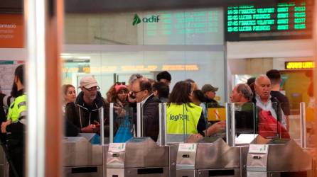 Imagen de los pasajeros junto al panel que informa de los retrasos. Foto: ACN