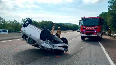 El coche ha quedado volcado en el carril central. Foto: Bombers