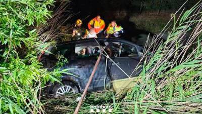 El coche accidentado y los bomberos trabajando. Foto: Bombers de la Generalitat
