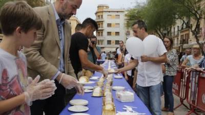 Centenares de personas de todas las edades acudieron ayer por la tarde a la Plaça de la Font para probar las raciones del tradicional Pastís del Braç de Santa Tecla. Foto: Pere Ferré