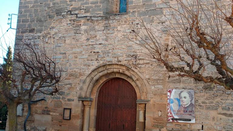 L’església de Vallfogona convertida en espai d’interpretació. A la façana, a la dreta, un cartell amb la imatge del rector. Foto: Àngel Juanpere