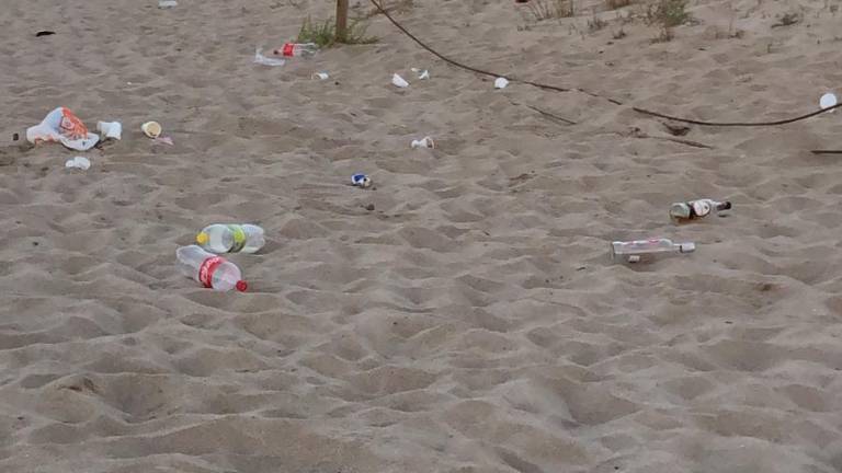 Restos de un botellón en la arena, frente al Nàutic Creixell.