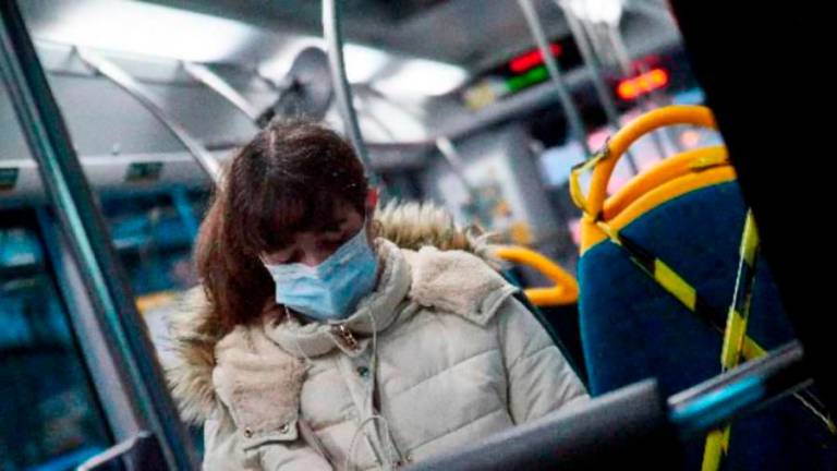 Una mujer con mascarilla en un autobús. Foto: EFE