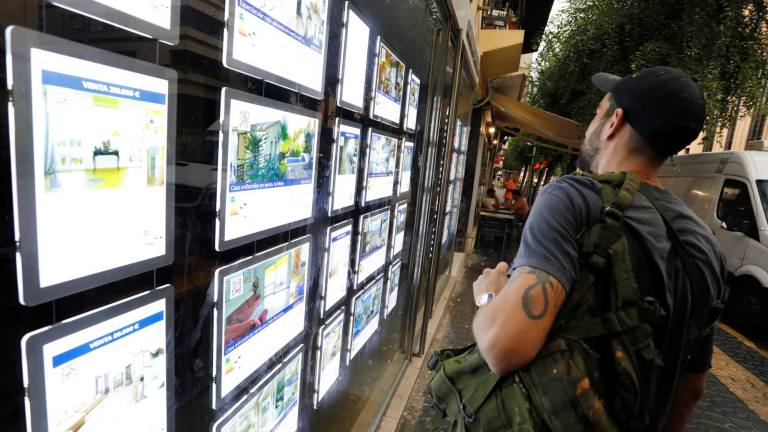 Un joven observa anuncios de inmuebles en el escaparate de una inmobiliaria de la Rambla Vella, en Tarragona. Foto: Pere Ferré/DT