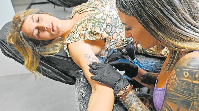 La tatuadora Raquel Moya Ruiz con una cliente. Foto: A. G.