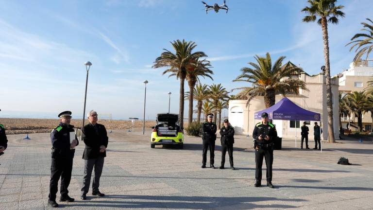 Unos agentes de la Policía Local observan el dron, en el momento de elevarse. foto: Pere Ferré