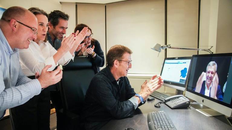 El presidente del PP, Alberto Núñez Feijóo, y otros dirigentes manteniendo ayer noche una videoconferencia con el candidato del partido en Galicia, Alfonso Rueda. Los populares revalidan la mayoría absoluta, lo que refuerza el liderazgo de Núñez Feijóo en el partido. foto: efe