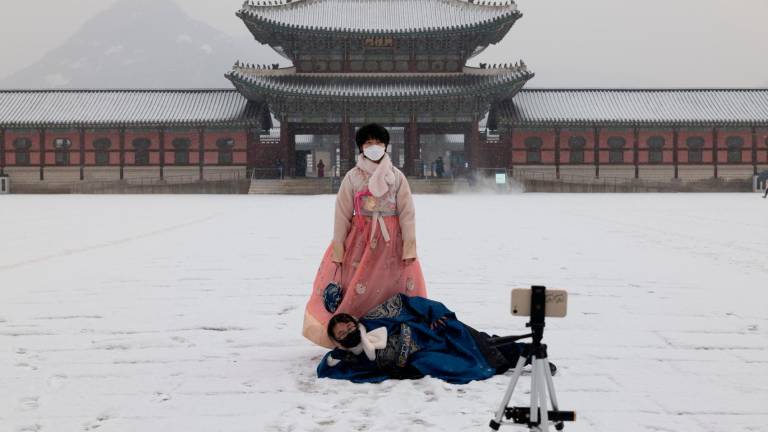 Dos mujeres ataviadas con trajes tradicionales posan en la nieve durante una visita al Palacio Gyegbokgung de Seúl, Corea del Sur. Foto: EFE/Jeon Heon-Kyun