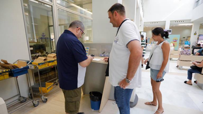 El personal de Correos indicando los pasos a seguir a los votantes. Foto: Pere Ferré