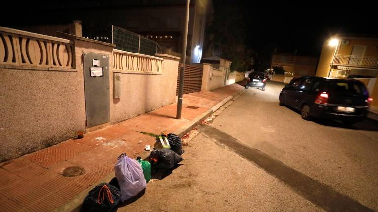 Vecinos dejan bolsas de basura en plena calle, donde antes había contenedores que ahora se han trasladado. Foto: Pere Ferré