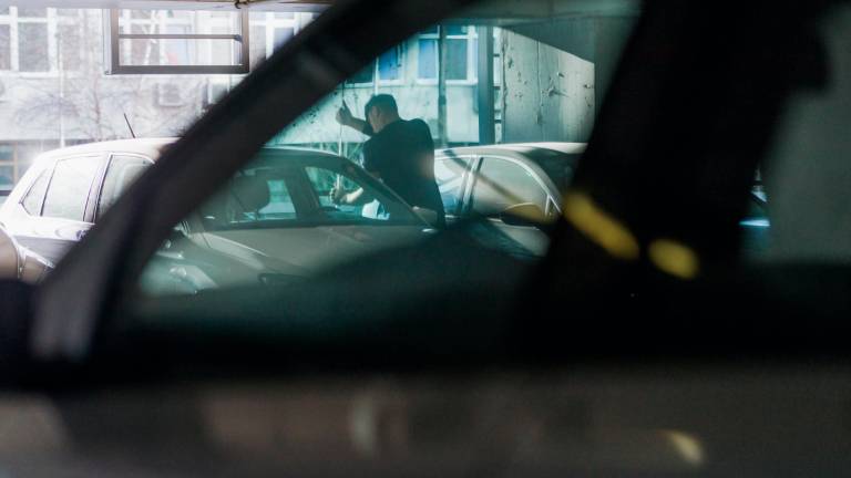 Un ladrón forzando una puerta de un coche en un aparcamiento. Foto: Getty Images