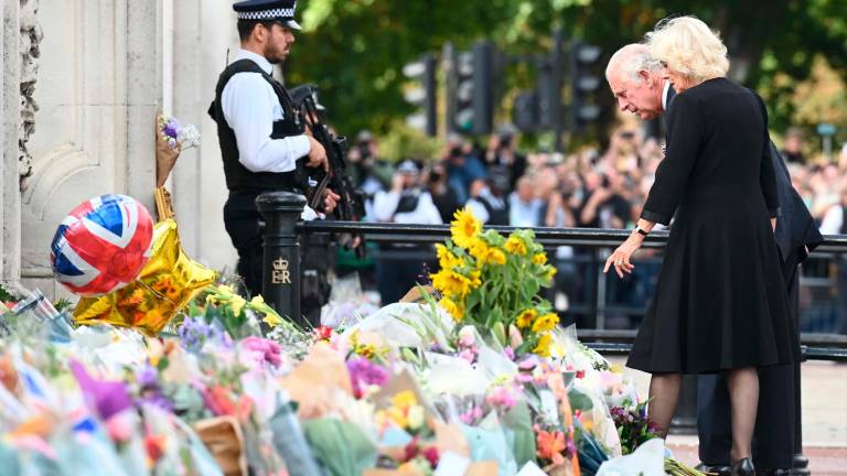 El nuevo monarca inglés y su esposa Camila dieron un paseo para admirar las muestras de cariño de la difunta Isabel II. FOTO: EFE