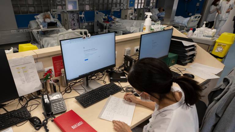 Una sanitaria del Hospital Clínic de Barcelona trabaja tomando notas a mano este lunes después del ciberataque «complejo» sufrido a principios de marzo. Foto: EFE