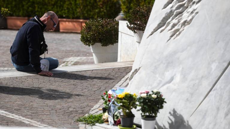 Un fiel reza frente a la estatua de Juan Pablo II en la entrada del hospital Gemelli, donde el papa Francisco está hospitalizado, en Roma. Foto: EFE