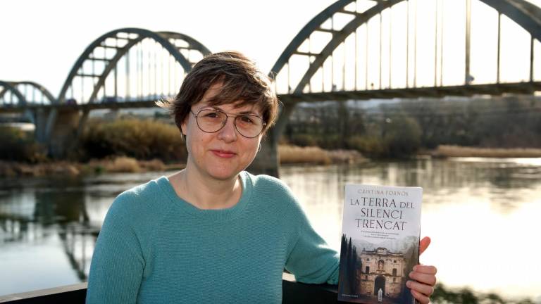 La periodista Cristina Fornós amb la seva primera novel·la ‘La terra del silenci trencat’. FOTO: Joan Revillas